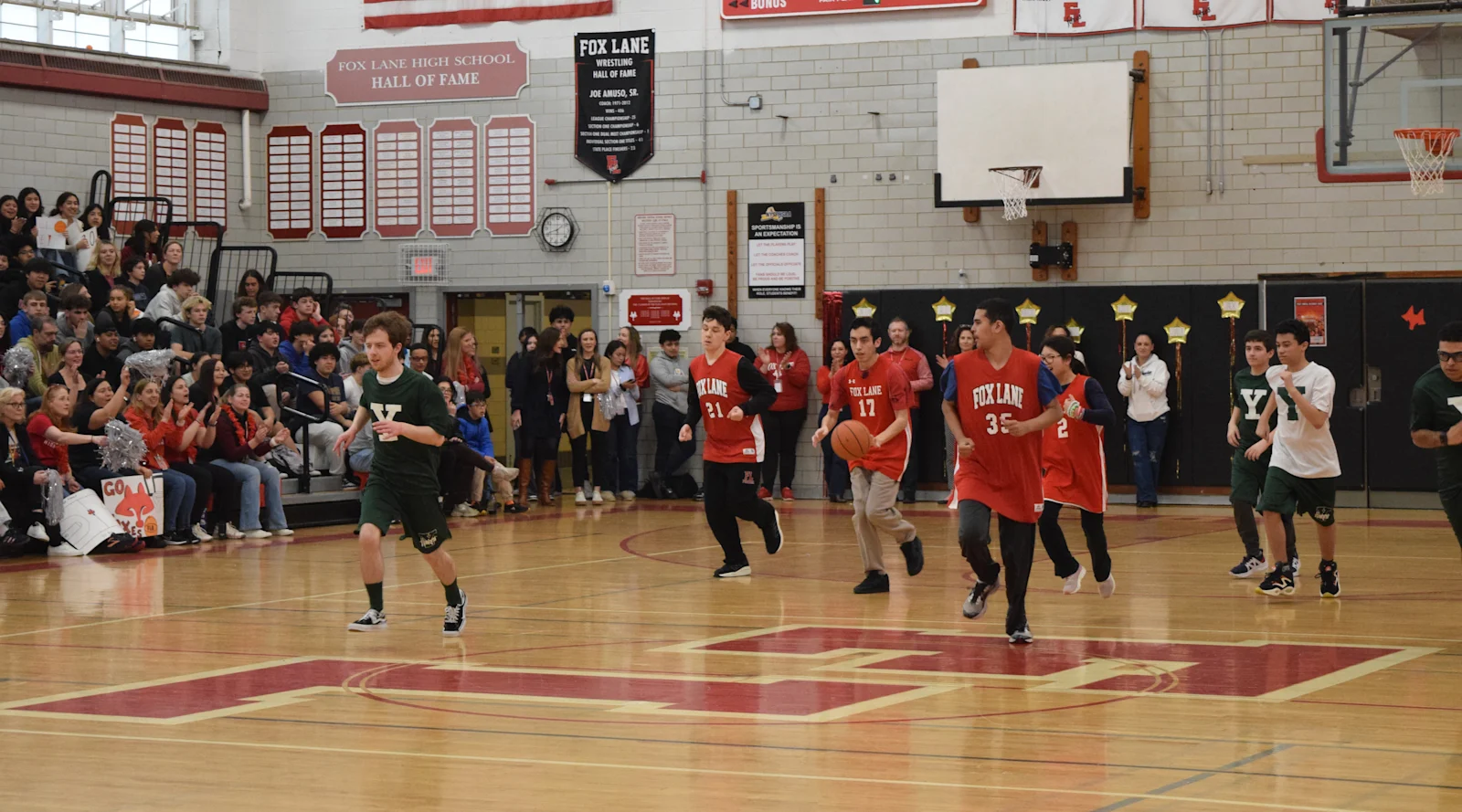 Pioneer team players take the ball down the court in the Fox Lane gym